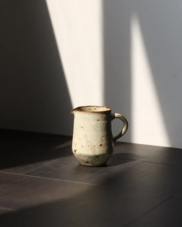 Artist Collaboration Stoneware Coffee Mug and Jug in olive — in a room setting