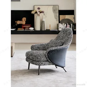 Saddle Leather and Linen Lounge Chair on Steel Base in black — in a room setting