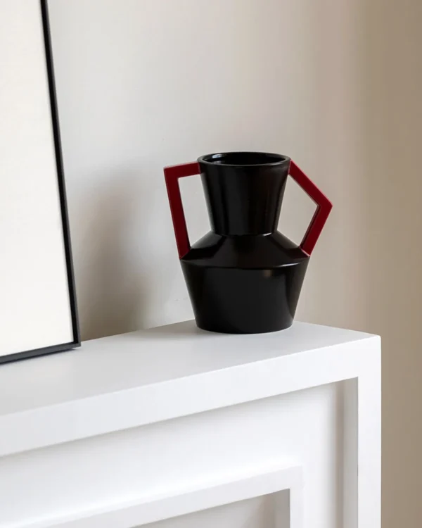 Angular Black Ceramic Vase with Red Square Handles in black — in a room setting
