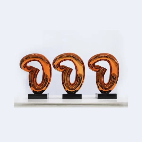 Amber Glass Loop Sculpture on Black Base, 30 x 43.5 cm in rust — in a room setting