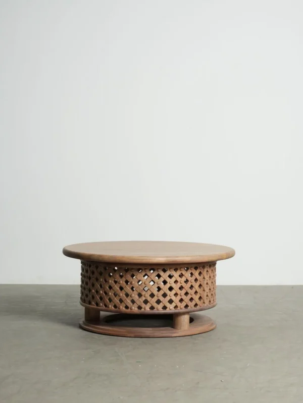 Round Teak Coffee Table with Lattice Drum Base, 110 cm in natural oak — in a room setting