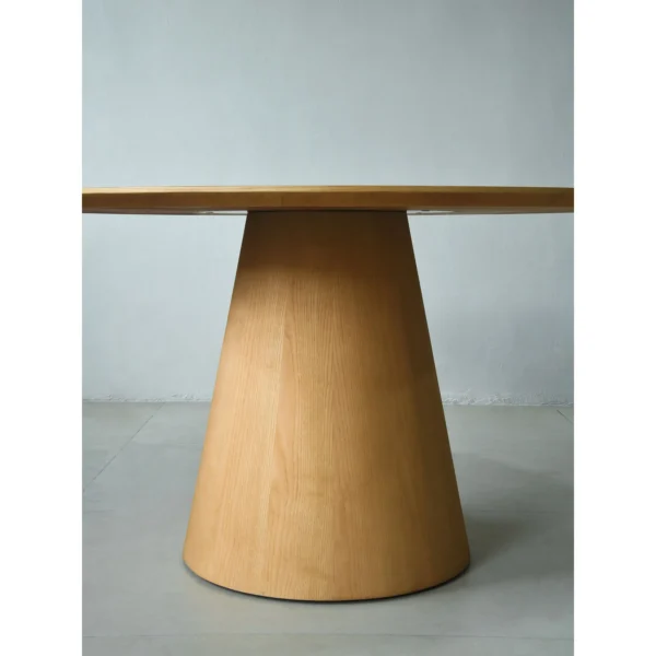 Solid Ash Round Dining Table on Cone Base in natural oak — in a room setting