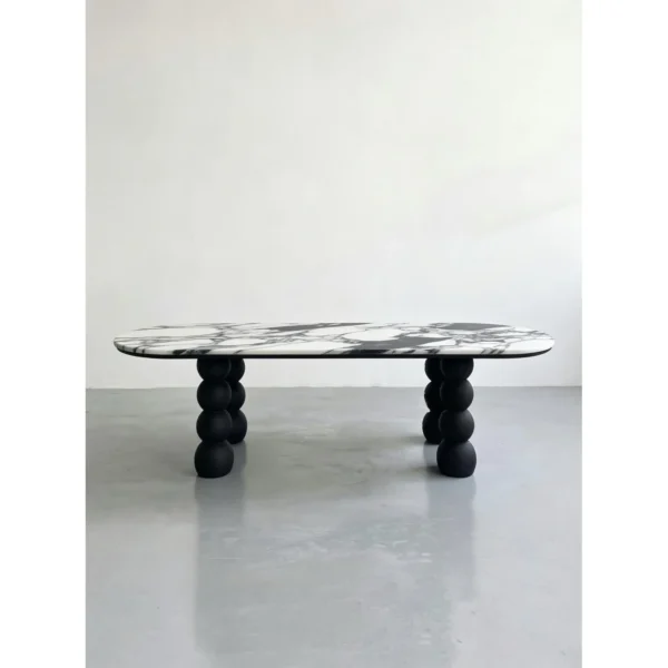 White Marble Oval Table on Black Ash Sphere Legs in ivory — in a room setting