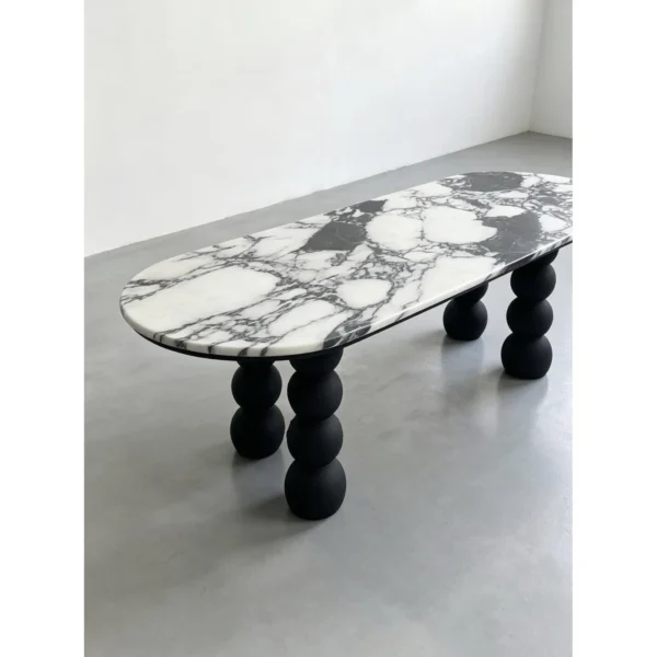 White Marble Oval Table on Black Ash Sphere Legs in ivory — in a room setting
