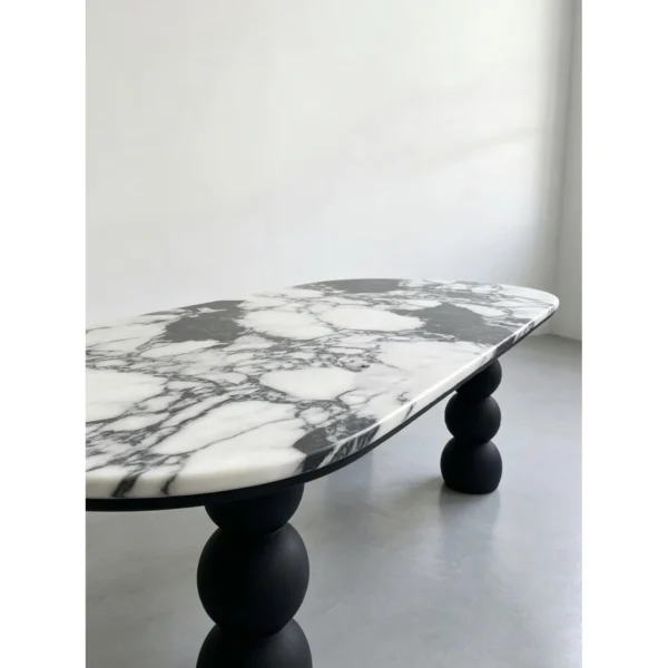 White Marble Oval Table on Black Ash Sphere Legs in ivory — in a room setting