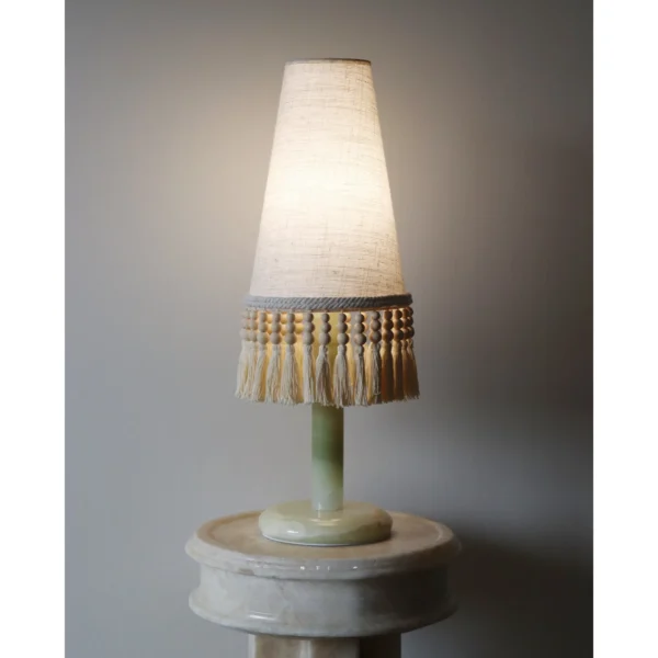 Woven Shadow Fringed Fabric Table Lamp in oatmeal — in a room setting