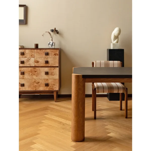 Bedrock Dining Table with Dark Top and Burl Cylinder Legs in black — in a room setting