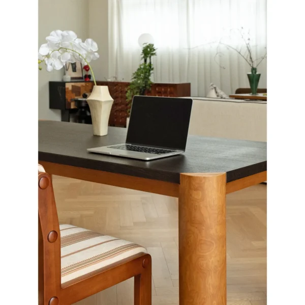 Bedrock Dining Table with Dark Top and Burl Cylinder Legs in black — in a room setting