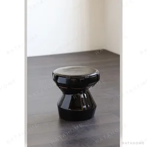 Black Glazed Drum Stool with Tan Leather Straps in black — in a room setting