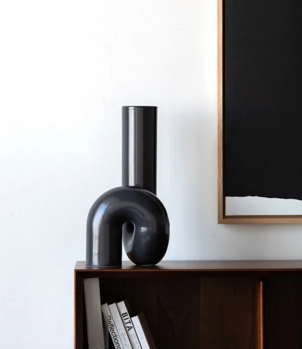 Black Twisted Tube Sculptural Ceramic Vase in black — in a room setting