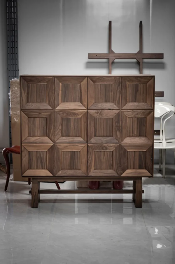 Black Walnut Faceted-Panel Cabinet on Trestle Base in walnut — in a room setting