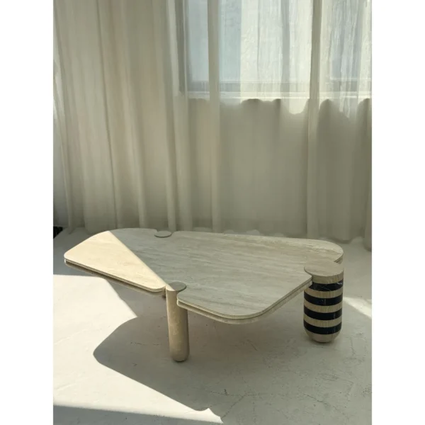 Travertine Geometric Coffee Table with Striped Stone Leg in sand — in a room setting