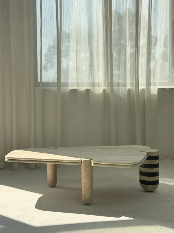 Travertine Geometric Coffee Table with Striped Stone Leg in sand — in a room setting