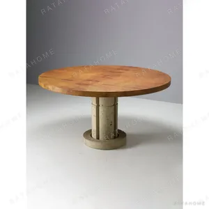 Golden Burl Round Dining Table on Carved Travertine Base in rust — in a room setting