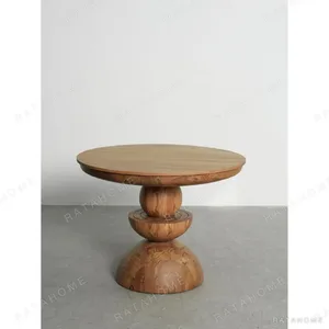 Burmese Teak Round Table on Stacked Sphere Base in natural oak — in a room setting