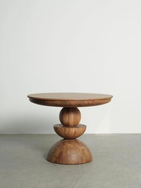 Burmese Teak Round Table on Stacked Sphere Base in natural oak — in a room setting