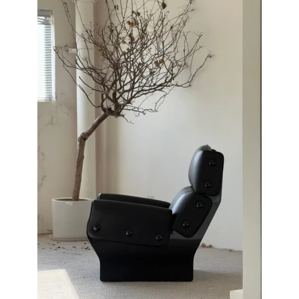 Matte Black Leather Study Lounge Chair with Metal Studs in black — in a room setting