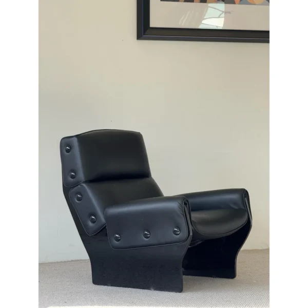 Matte Black Leather Study Lounge Chair with Metal Studs in black — in a room setting
