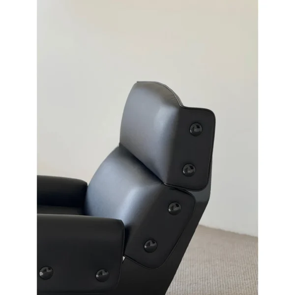 Matte Black Leather Study Lounge Chair with Metal Studs in black — in a room setting