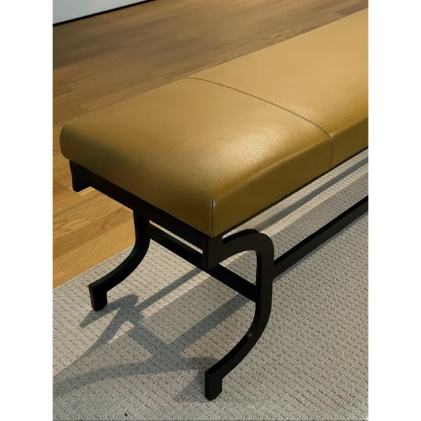 Curved Bronze Leg Bench with Caramel Leather Seat in clay — in a room setting