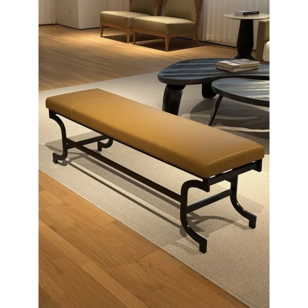 Curved Bronze Leg Bench with Caramel Leather Seat in clay — in a room setting