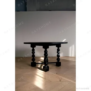 Courtyard Black Round Table on Hand-Carved Column Legs in black — in a room setting