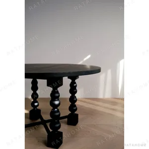 Courtyard Black Round Table on Hand-Carved Column Legs in black — in a room setting