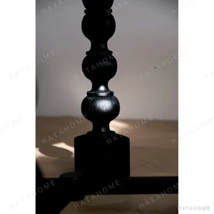Courtyard Black Round Table on Hand-Carved Column Legs in black — in a room setting
