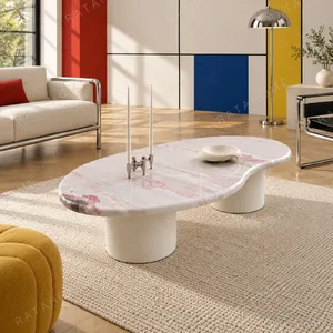 Pink Marble Organic Coffee Table on White Cylinder Legs in rose stone — in a room setting