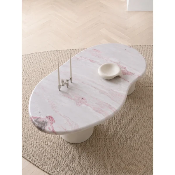 Pink Marble Organic Coffee Table on White Cylinder Legs in rose stone — in a room setting