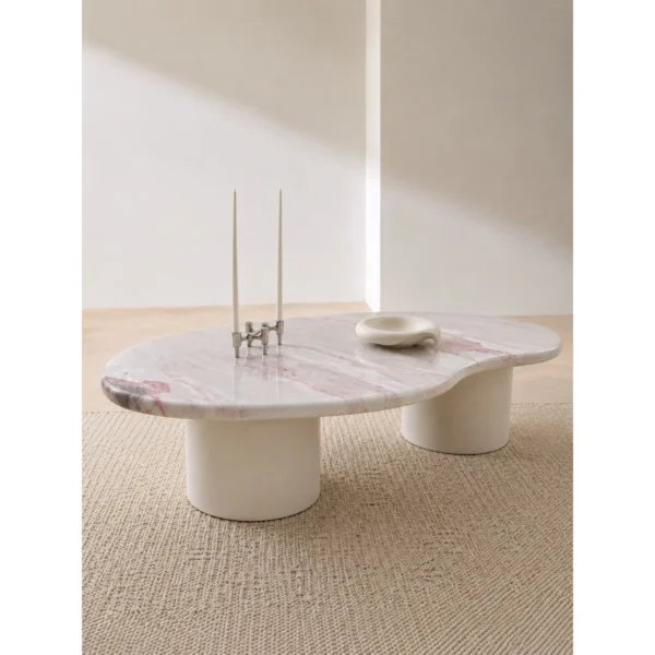 Pink Marble Organic Coffee Table on White Cylinder Legs in rose stone — in a room setting
