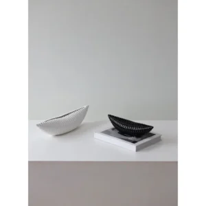 Glossy Black Ribbed Boat Bowl Ornament, Small in black — in a room setting