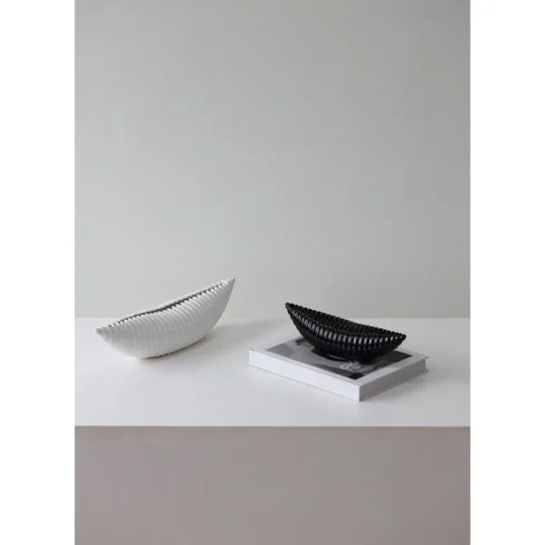 Glossy Black Ribbed Boat Bowl Ornament, Small in black — in a room setting