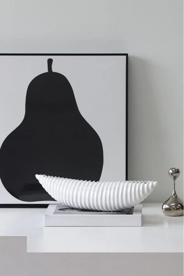 Glossy Black Ribbed Boat Bowl Ornament, Small in black — in a room setting