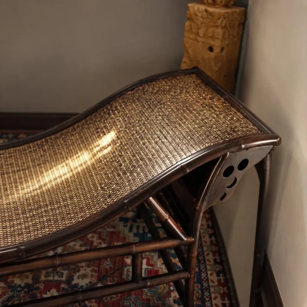 Curved Bamboo and Woven Cane Chaise Lounge in black — in a room setting