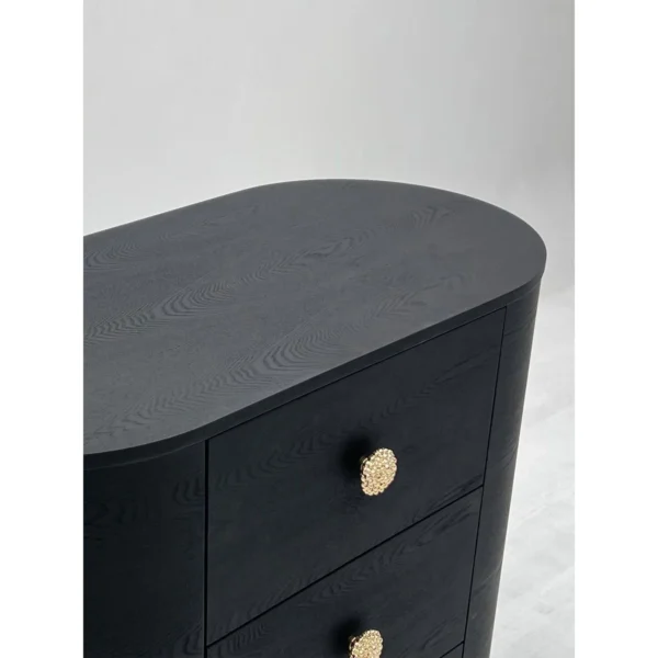 Curved Black Ash Three-Drawer Chest on Champagne Base in black — in a room setting