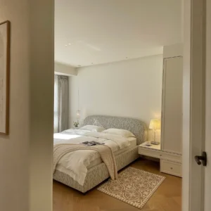 Curved Cotton-Linen Bed with Inset Mattress Frame in sand — front view