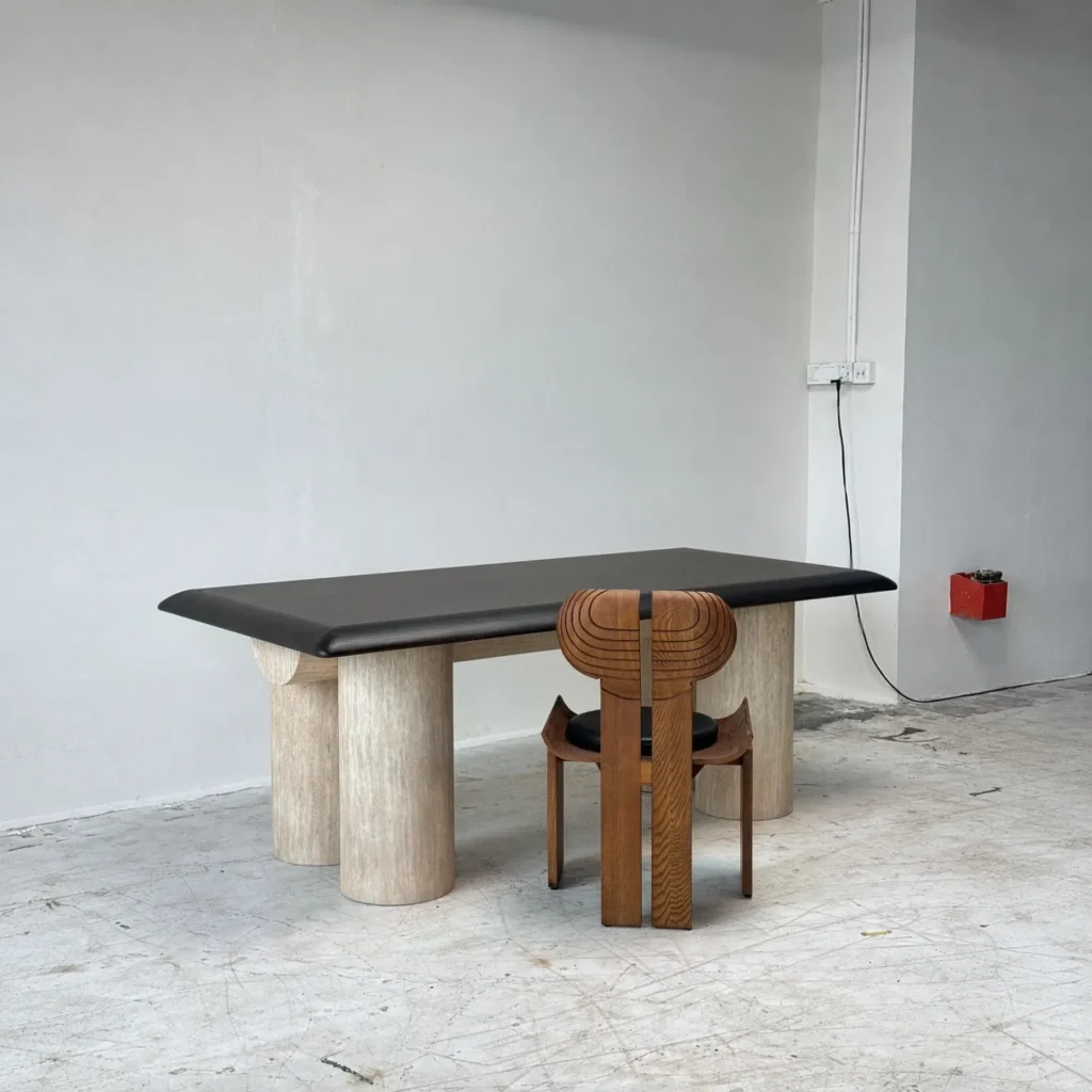 Black Bevelled Wood Table on Travertine Cylinder Base in black — front view