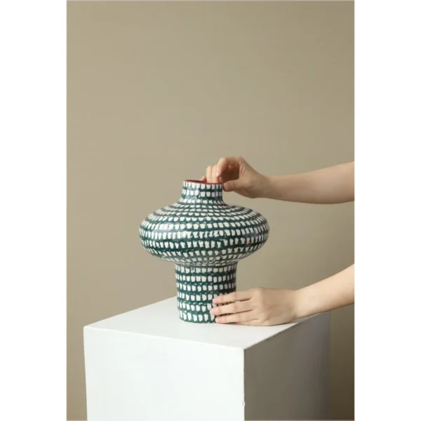 Artist-Made Teal Grid Spinning-Top Vase with Red Rim, Medium in olive — in a room setting