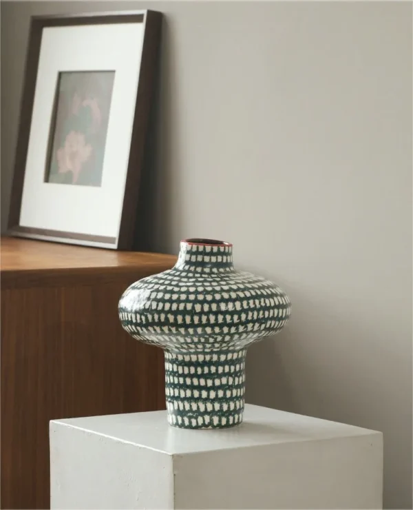 Artist-Made Teal Grid Spinning-Top Vase with Red Rim, Medium in olive — in a room setting