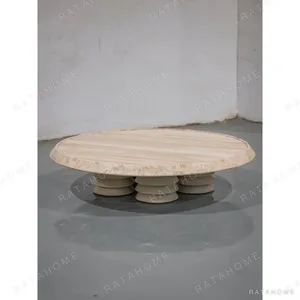 Round Travertine Coffee Table on Fluted Stone Column Base in oatmeal — in a room setting