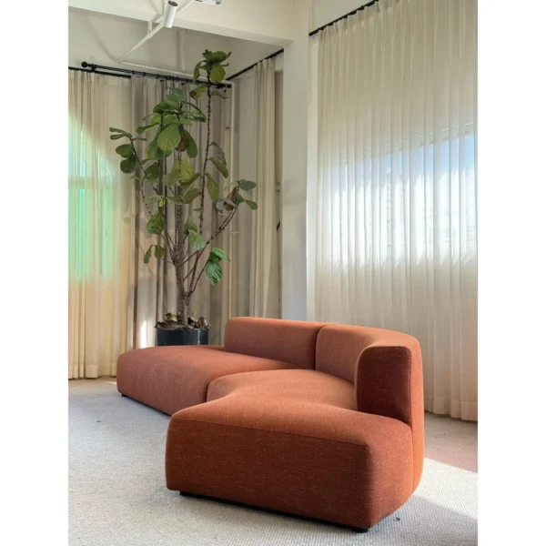 Gently Curved Modular Sofa in rust — in a room setting