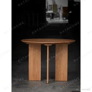 Solid Oak Round Table with Angled Panel Base in natural oak — in a room setting
