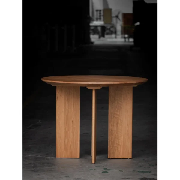 Solid Oak Round Table with Angled Panel Base in natural oak — in a room setting