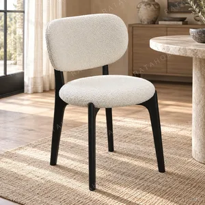 Bouclé Pillow-Back Dining Chair on Black Legs in oatmeal — in a room setting