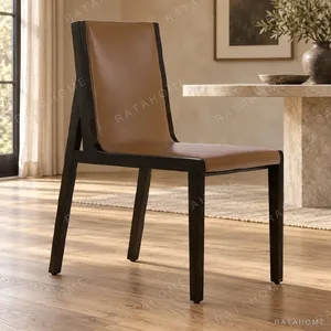 Tan Leather Sling Dining Chair on Black Frame in clay — in a room setting