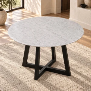 White Marble Round Table on Black Crossed-Panel Base in ivory — in a room setting