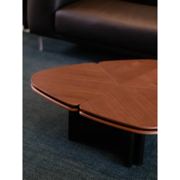 Clover Coffee Table in Vintage-Toned Wood — in a room setting