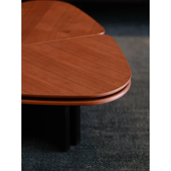 Clover Coffee Table in Vintage-Toned Wood — in a room setting