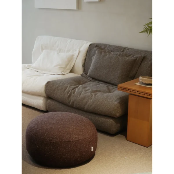 Floating Dot Round Pouf in Burgundy Textured Fabric — in a room setting